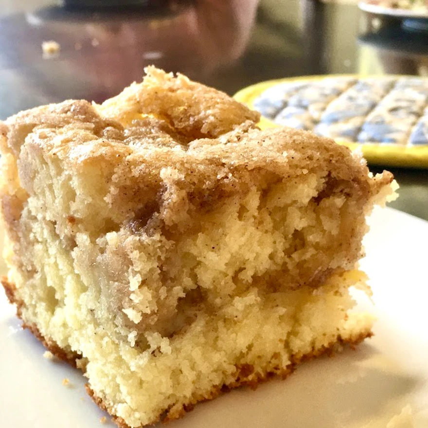 A slice of cinnamon streusel coffee cake with a layer of streusel in the middle and a streusel topping. 