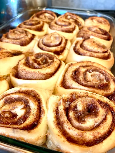 Baked cinnamon rolls showing four spirals filled with cinnamon. 